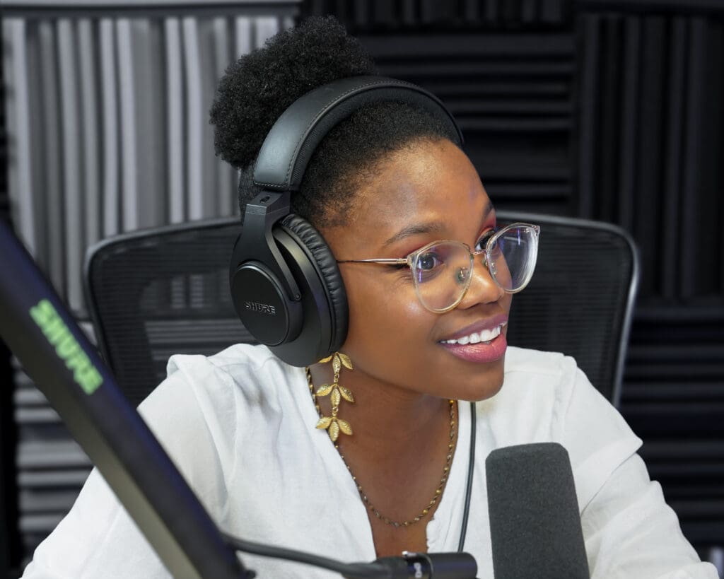 Podcast guest, woman speaking into microphone and smiling