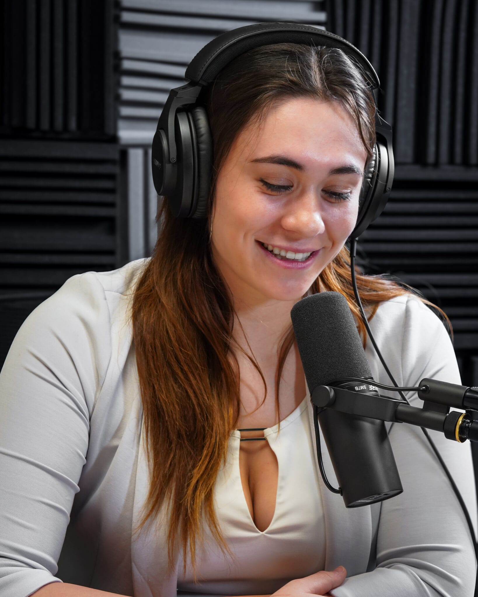 Podcast host, woman speaking into a microphone